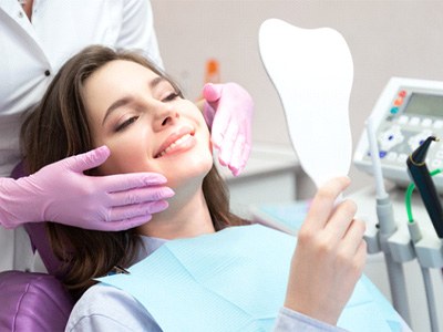 A woman admiring the results of the cosmetic dental treatment