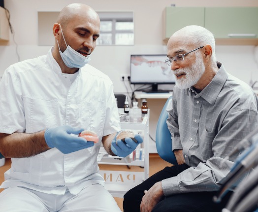 A dentist explaining the types of dentures to his patient