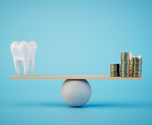 A model tooth and stack of coins set on a balance beam